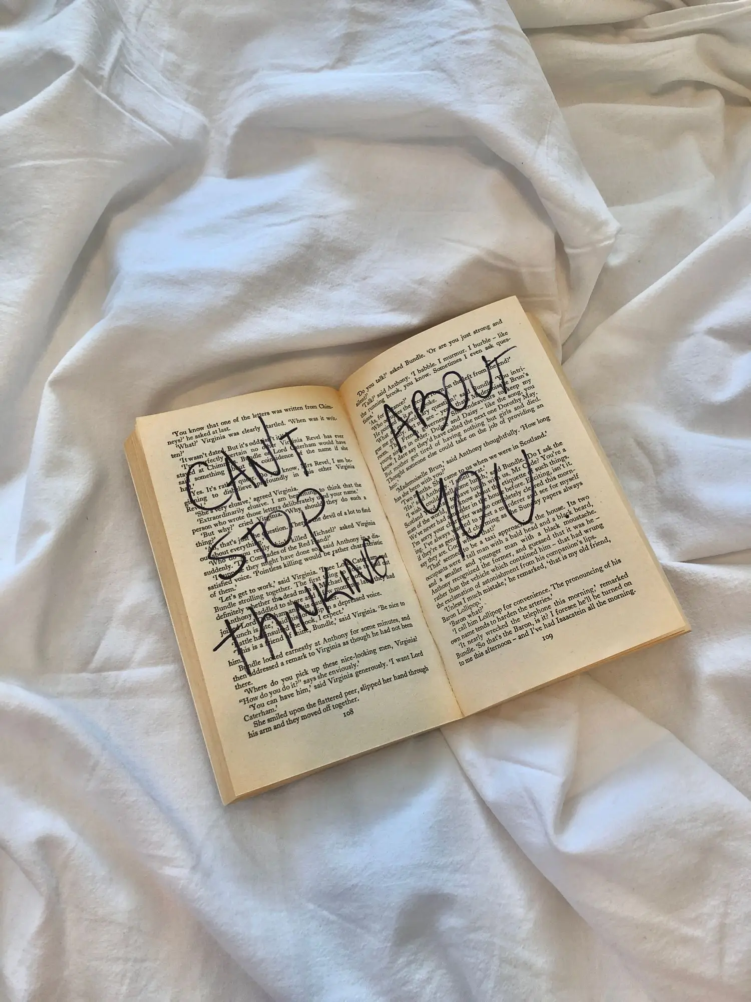 Open annotated book on a bed