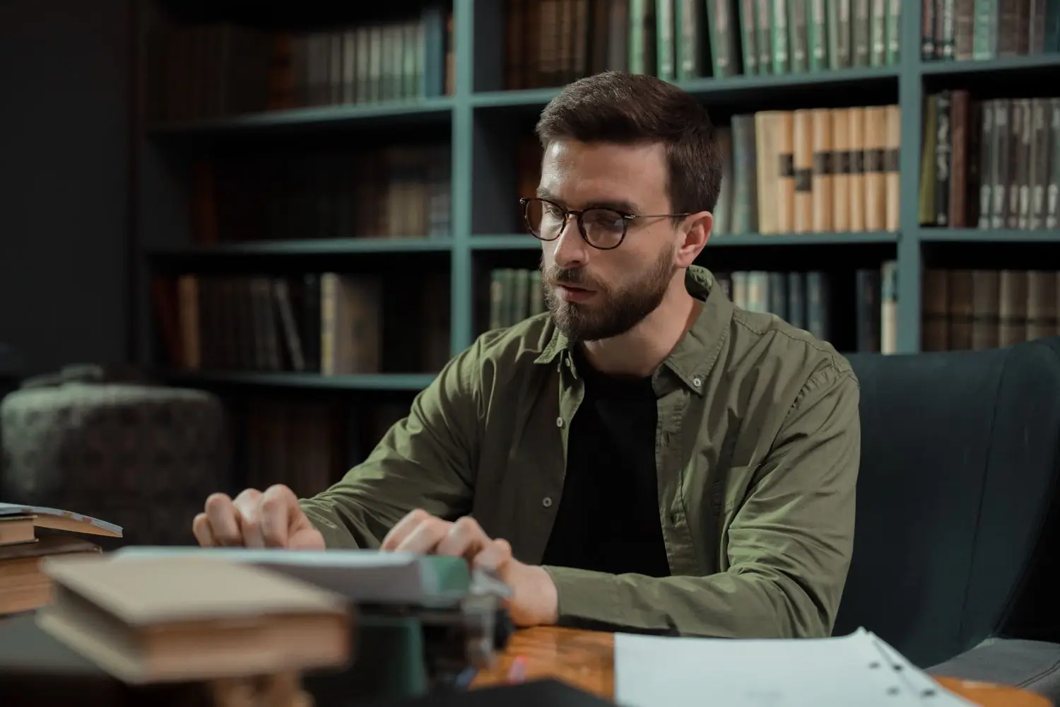 Writer seated at a table in front of books